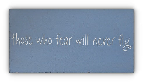 A handmade wooden plaque with a blue background and white text that reads 'those who fear will never fly'.